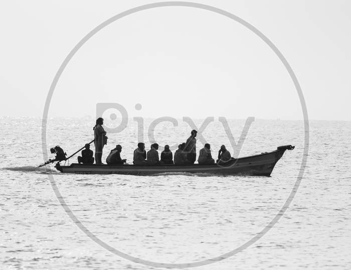 KARAIKAL, PONDICHERRY - Jan 23, 2020:  Karaikal  island. Sailing and other traditional boats with tourists on the sea against the  white silhouette background . fisherman boat