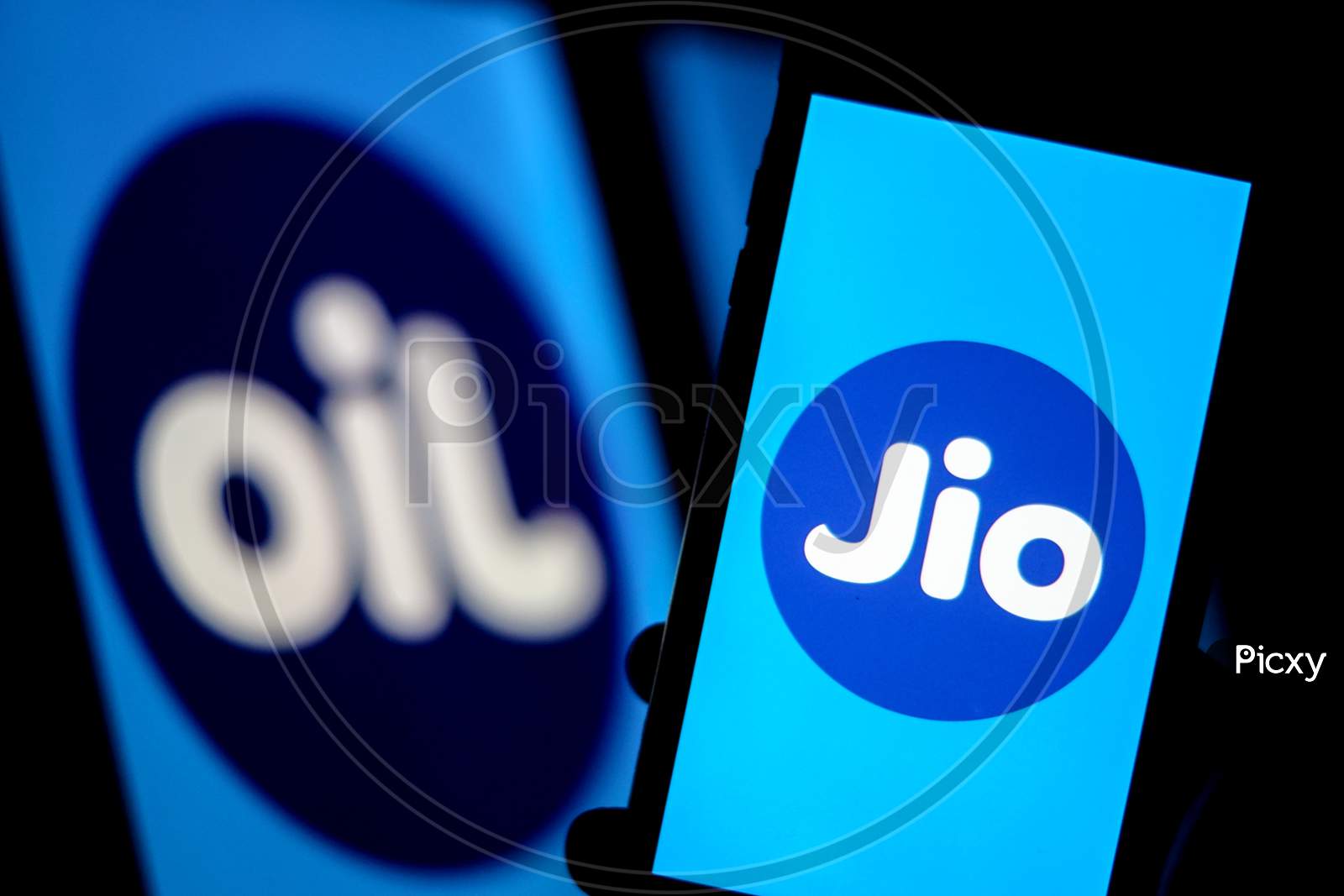Jio Logo in a Smartphone with Flipped Jio Logo as OIL in the Background