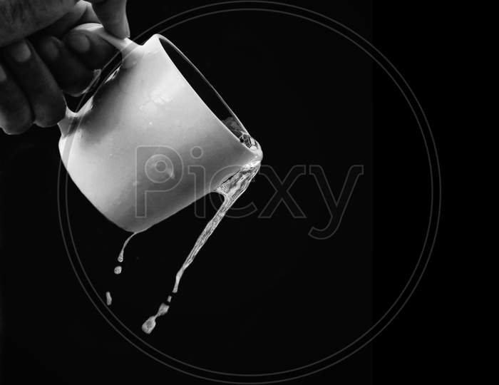 Black and white portrait of water falling from a cup