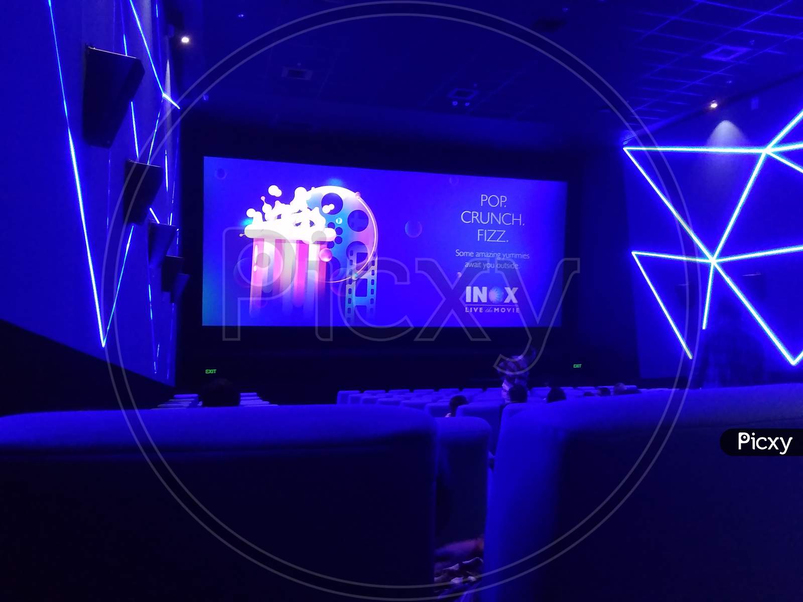 Kolkata, West Bengal/India - January 1, 2019: Blue seats or chairs and hall wall's and screen display under dim light inside INOX movie hall at Madhyamgram, Star Mall.