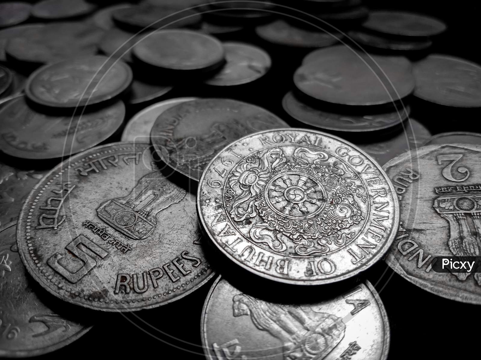 lots of coins image in black background with selective blur