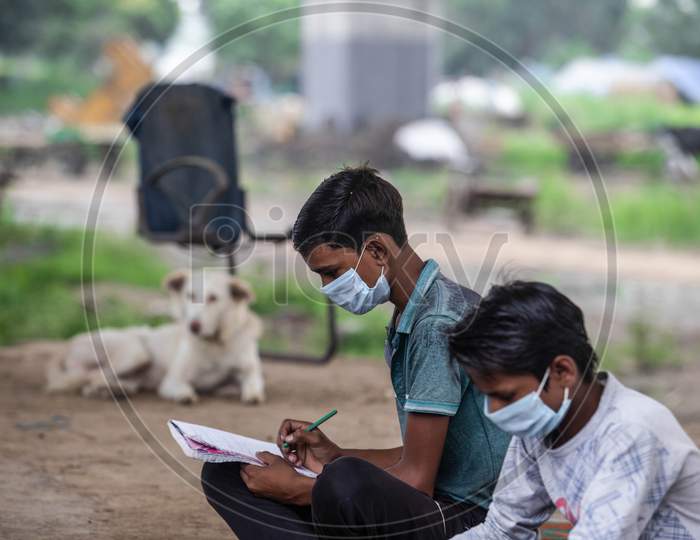Two students attend an offline class conducted by Satyendra Pal, a Delhi teacher in Yamuna Khadar, New Delhi on July 06, 2020