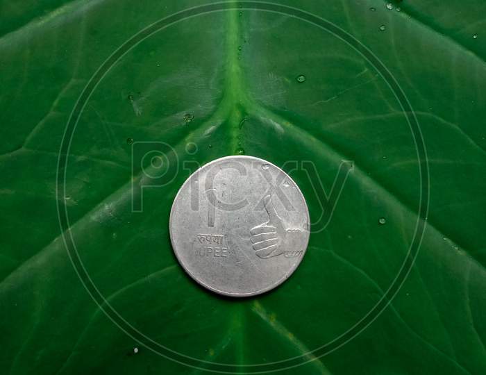 one rupee coin image in green background  with some selective focus
