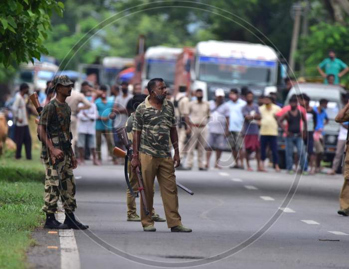 Forest officials stand guard on National Highway-37 after a tigress escaped from the Kaziranga National Park and strayed into a house in Nagaon, Assam on July 15, 2020
