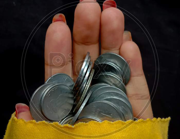 hand with silver coin in black background