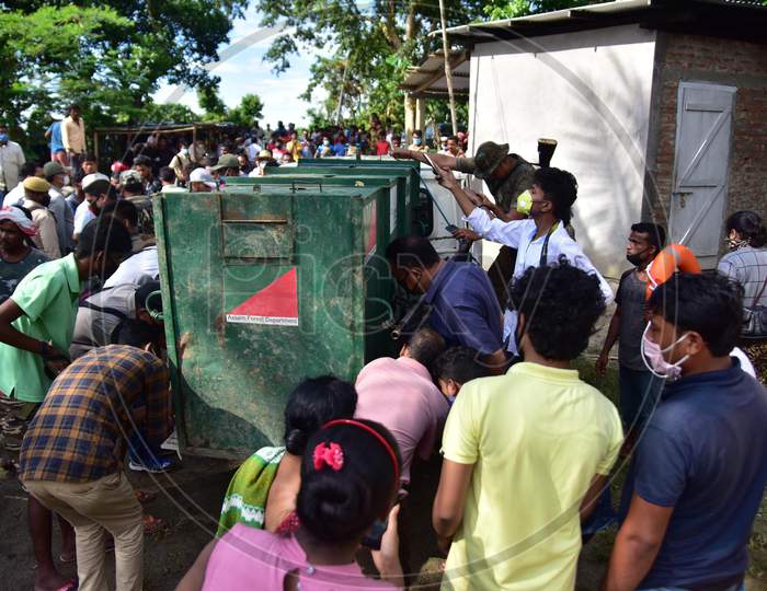 People look at the cage used to keep the tigress that strayed into a house in Nagaon, Assam on July 15, 2020