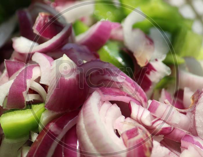 Fresh onion chopped salad pieces with green vegetables.