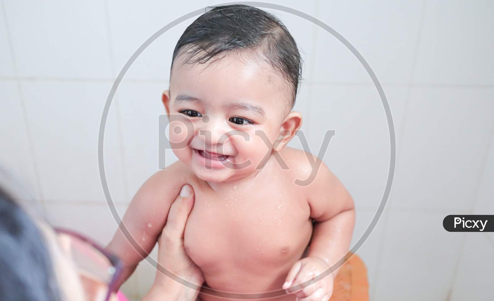 A Cute Indian Innocent New Born Baby In A Jovial Mood With A Charming Smile With Drops Of Water On His Body During Shower