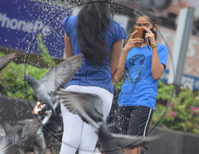 Hyderabad, Telangana, India. july-13-2020: the father and his daughters are feeding pigeons all around in corona virus pandemic time, peoples caring on birds, wearing mask