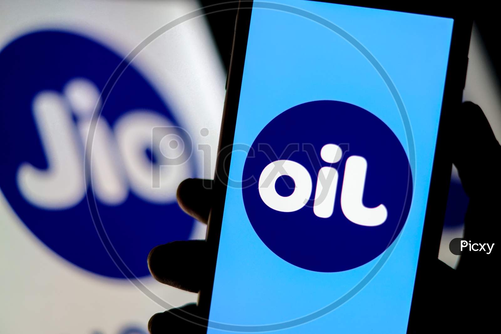 A Flipped Jio Logo as OIL on a Smartphone Screen with Jio Logo in the Background