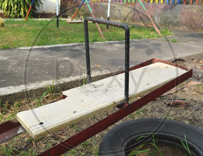 broken board of the seesaw with broken tire for safety pads