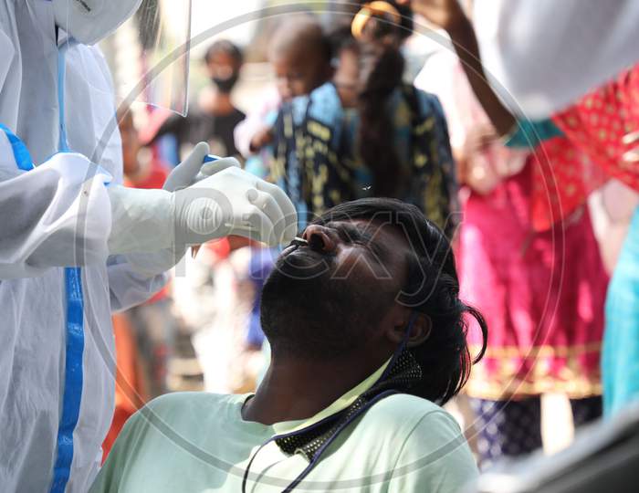 A health worker collects a swab sample from a man  for Covid-19 testing in Maratha Basti, Jammu on July 16, 2020