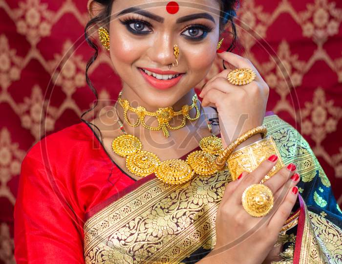 Portrait of a Beautiful Elegant Female Model in Traditional Ethnic Indian Asian Bridal Costume with Makeup and Heavy Jewellery with extra copy space.