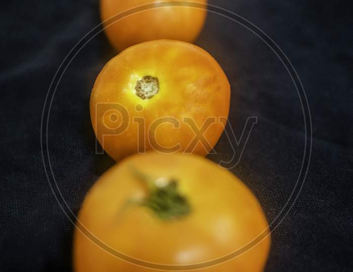 Three Tomatoes With Selective Focus In Black Background