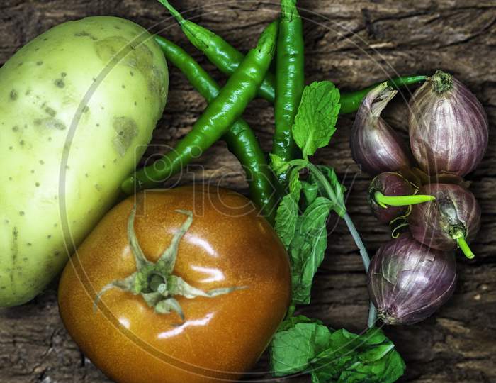 Mix Vegetables In Wooden Background, Tomato, Green Chilli, Potato, Mint And Small Shallot