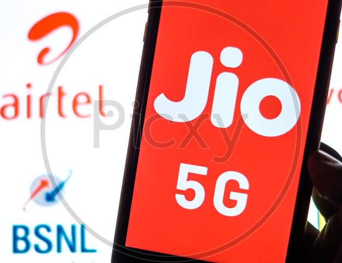 Close Up shot of a Mobilephone or Smartphone with Jio 5G on Screen and BSNL and Airtel Logo in the Background - A Concept of Jio 5G vs BSNL and Airtel 4G