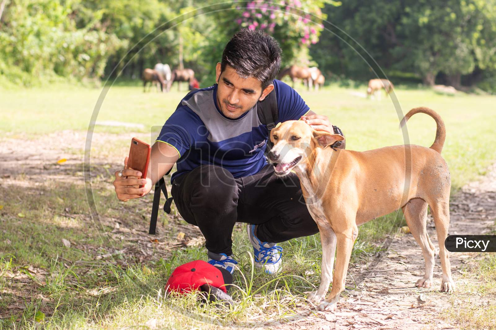 Young sports man taking selfie with dog in park, Animal lover and healthy sportsman concept.