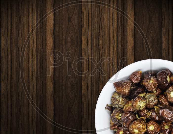 A Bunch Of Round Red Chillies In White Bowl In A Nice Wooden Backgrounda Bunch Of Round Red Chillies In White Bowl In A Nice Wooden Background