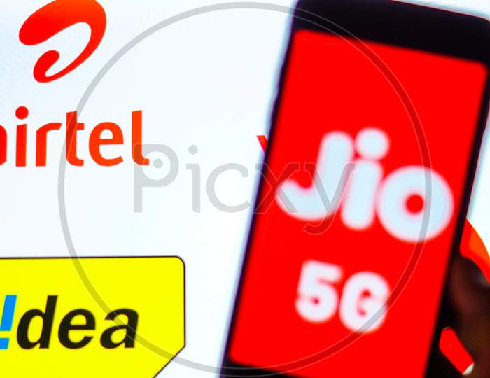 Close Up shot of a Mobilephone or Smartphone with Jio 5G on Screen and idea and Airtel Logo in the Background - A Concept of Jio 5G vs Idea 4G and Airtel 4G