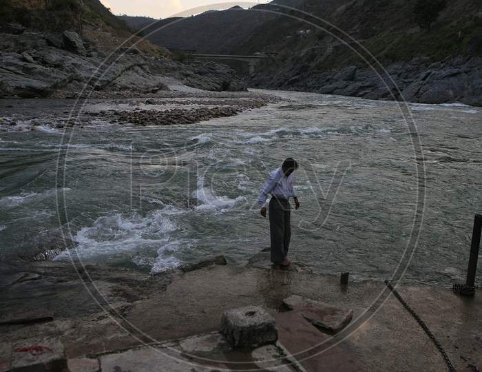 A Man Stands Near The Meeting Place Of The Two Indian River, Namly Alaknanda And Bhagirathi, And Its Called Devpryag, Its A Holy Place For The Indians.