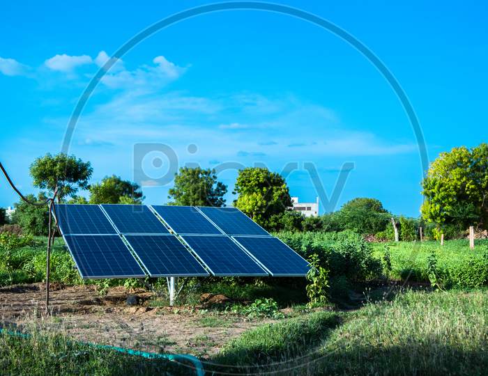 Solar Panel In Agriculture Field With Blue Sky, Green Environment.