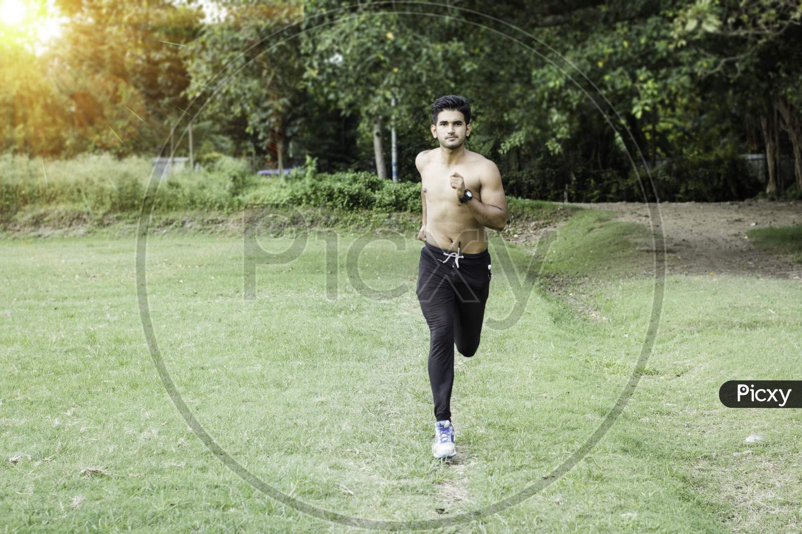 Athletic young man running in the nature. Healthy lifestyle , sports and fitness concept.