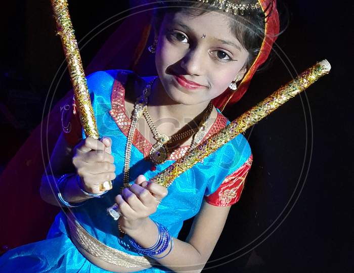 Cute child in daniya dress , hold dandiya in hands