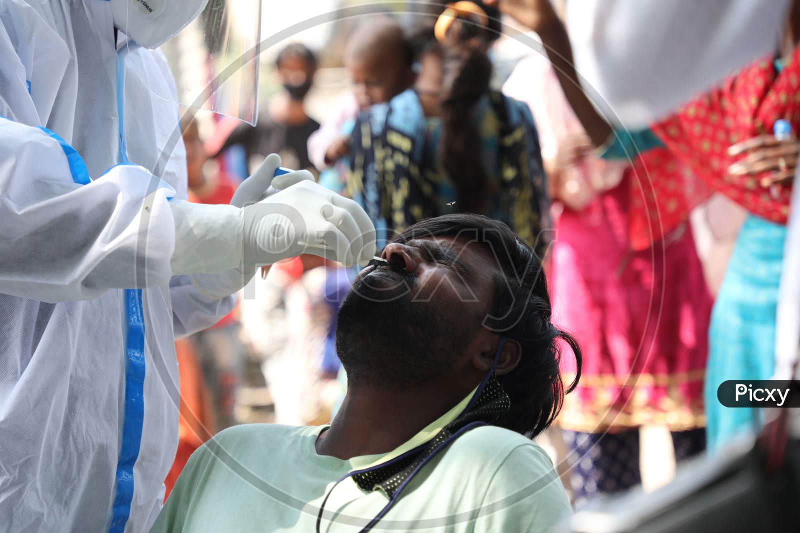 A health worker collects a swab sample from a man  for Covid-19 testing in Maratha Basti, Jammu on July 16, 2020