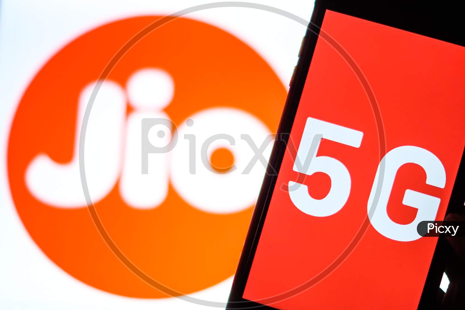 Close Up shot of a Mobilephone or Smartphone with 5G on Screen and Jio Logo in the Background - A Concept of Jio 5G