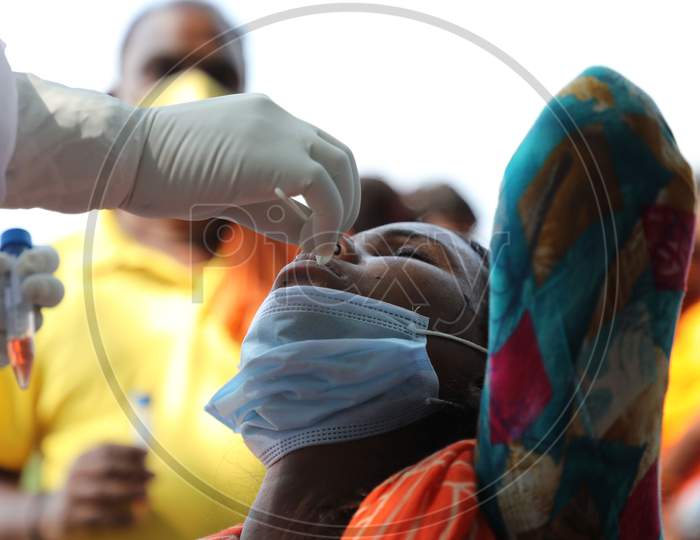 A health worker collects a swab sample from a child for Covid-19 testing in Maratha Basti, Jammu on July 16, 2020
