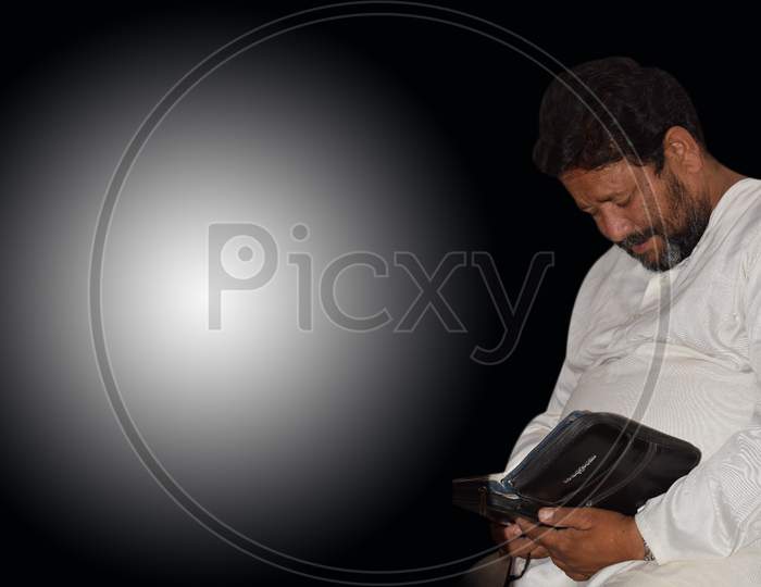A Middle Aged Person Reading Bible Isolated On Black And White Background