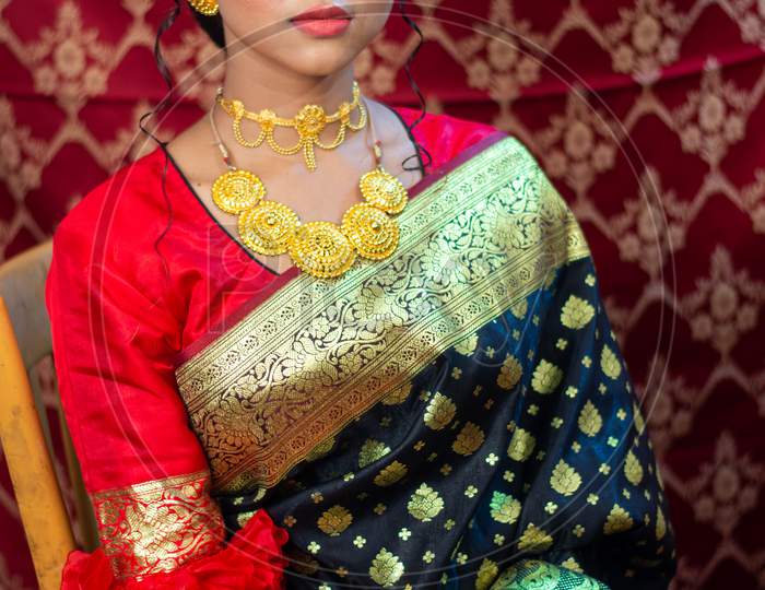 Portrait Of A Beautiful Elegant Female Model In Traditional Ethnic Indian Asian Bridal Costume With Makeup And Heavy Jewellery, Looking At Camera