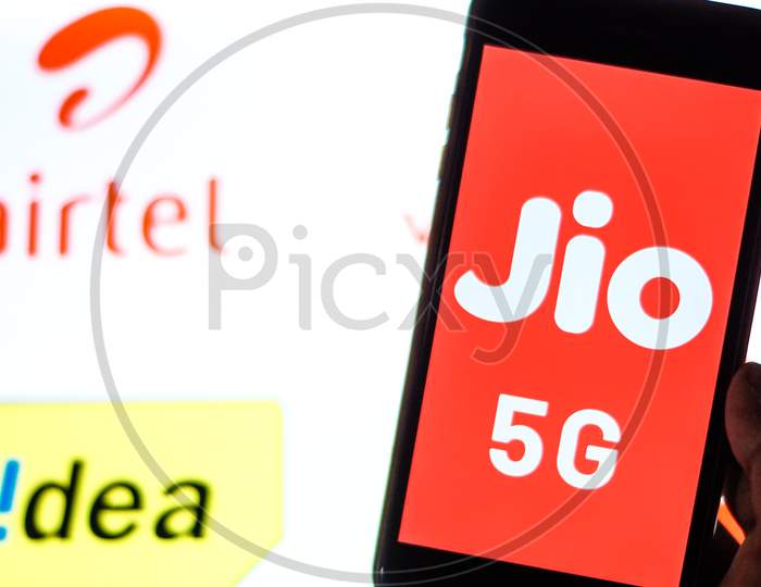 Close Up shot of a Mobilephone or Smartphone with Jio 5G on Screen and idea and Airtel Logo in the Background - A Concept of Jio 5G vs Idea 4G and Airtel 4G