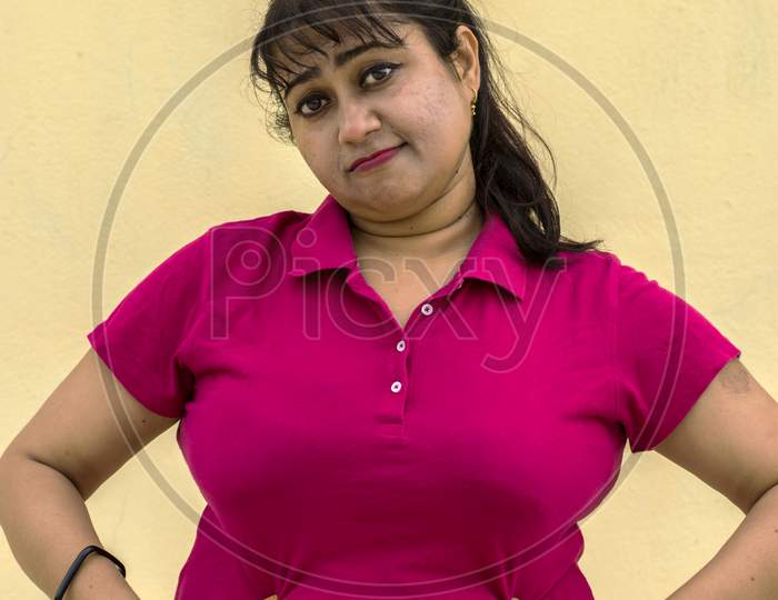 Indian Female Model Looking Down Unhappy With Her Fat Belly In Yellow Background With Copy Space For Text