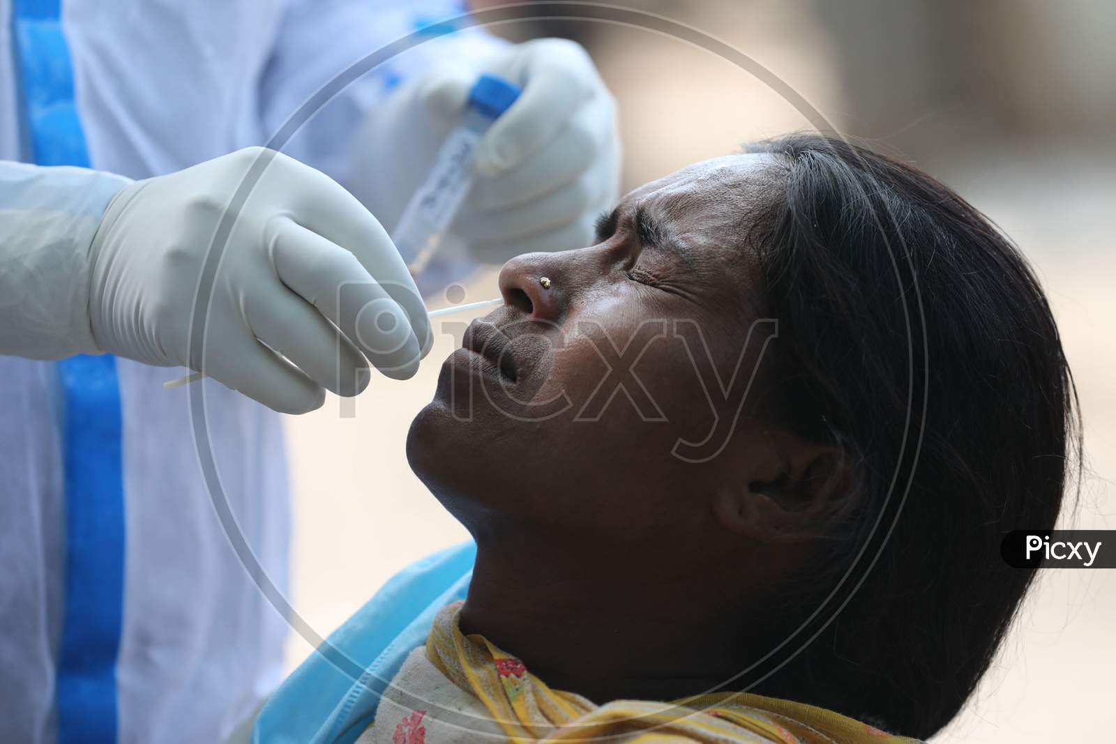 A health worker collects a swab sample from a woman for Covid-19 testing in Maratha Basti, Jammu on July 16, 2020