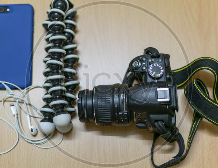 A Dslr And Gorilla Tripod With Mobile On A Table