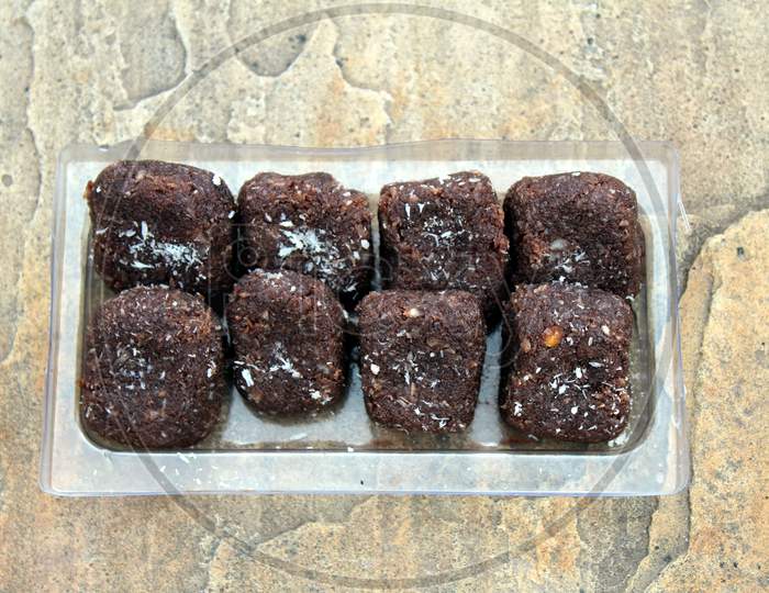 some chocolate sweets put in a glass tray on stone background