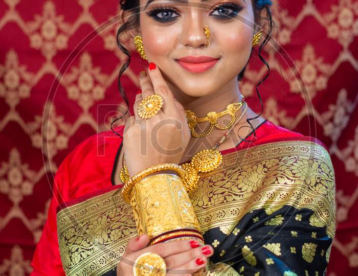 Portrait of a Beautiful Elegant Female Model in Traditional Ethnic Indian Asian Bridal Costume with Makeup and Heavy Jewellery with extra copy space.