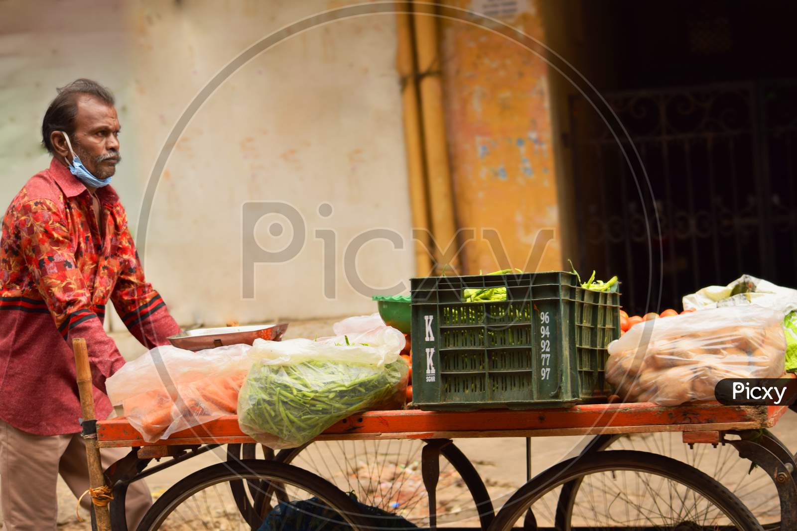 A Vegetables Trader Pushing His Cart On The Road