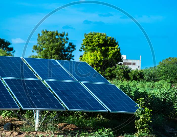 Small Solar Panel Installed In Agriculture Field With Blue Sky, Green Environment.