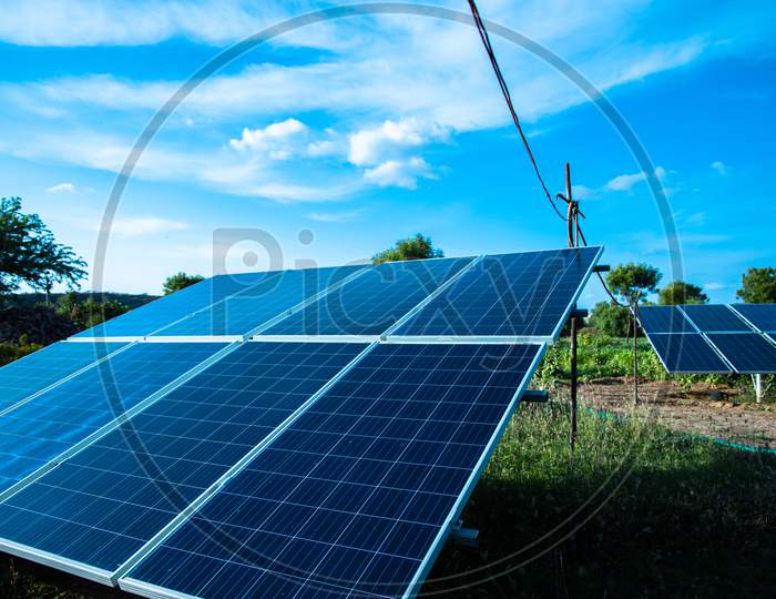 Solar Panel In Agriculture Field With Blue Sky, Green Environment.