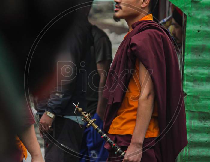 A Buddhist Monk Passing By The Road Towards Monastery While Doing Some Religious Spiritual Enchanting .