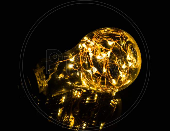 Night Photography, A Bulb With Lights Inside And Reflection With Black Background