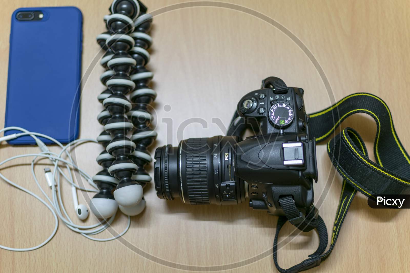 A Dslr And Gorilla Tripod With Mobile On A Table