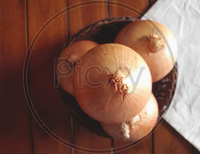 high angle view of onions arranged on a small basket with a white cloth base