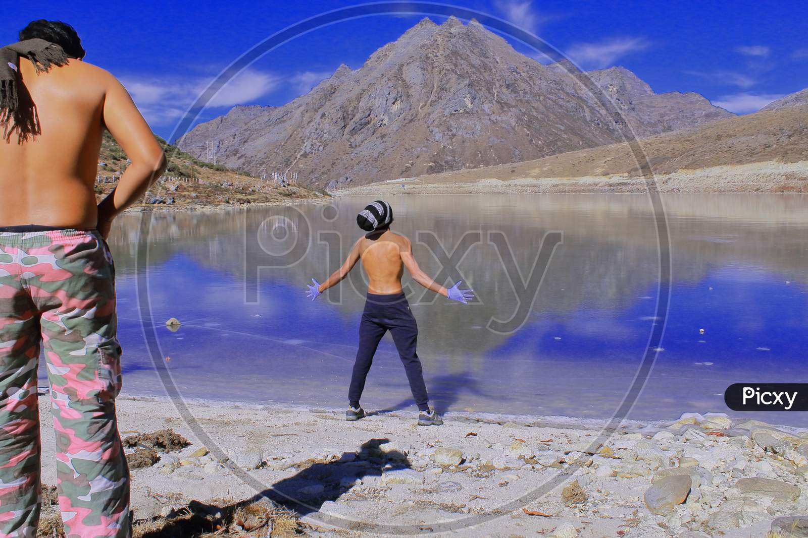 tourists or hikers are expressing their feelings and excitement infront of frozen sela lake, beautiful alpine lake is located in high himalayan region near sela pass, on the border between tawang and west kameng district in arunachal pradesh, north east india