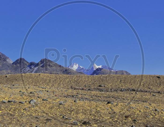 alpine barren tibetan landscape and snow capped mountains at bum la pass