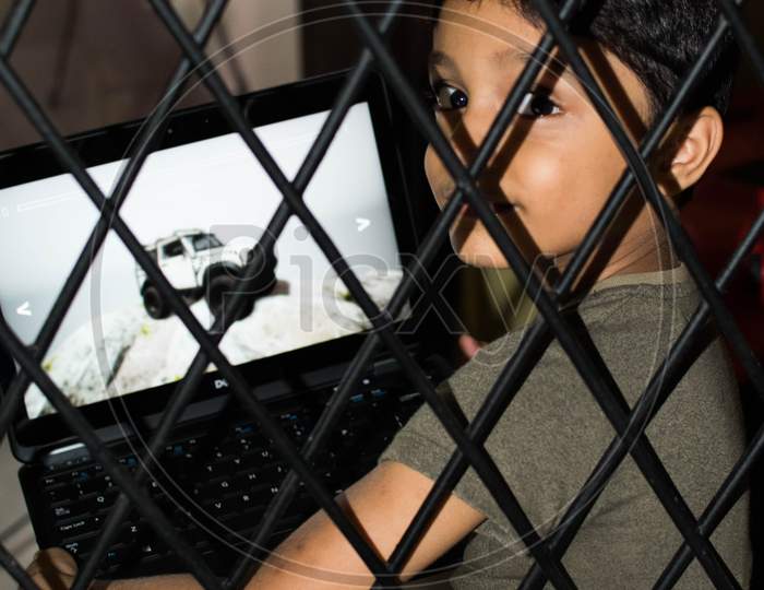A Boy Using Laptop During Home Quarrantine Due To Coronavirus, Online Learning, Home Isolation,