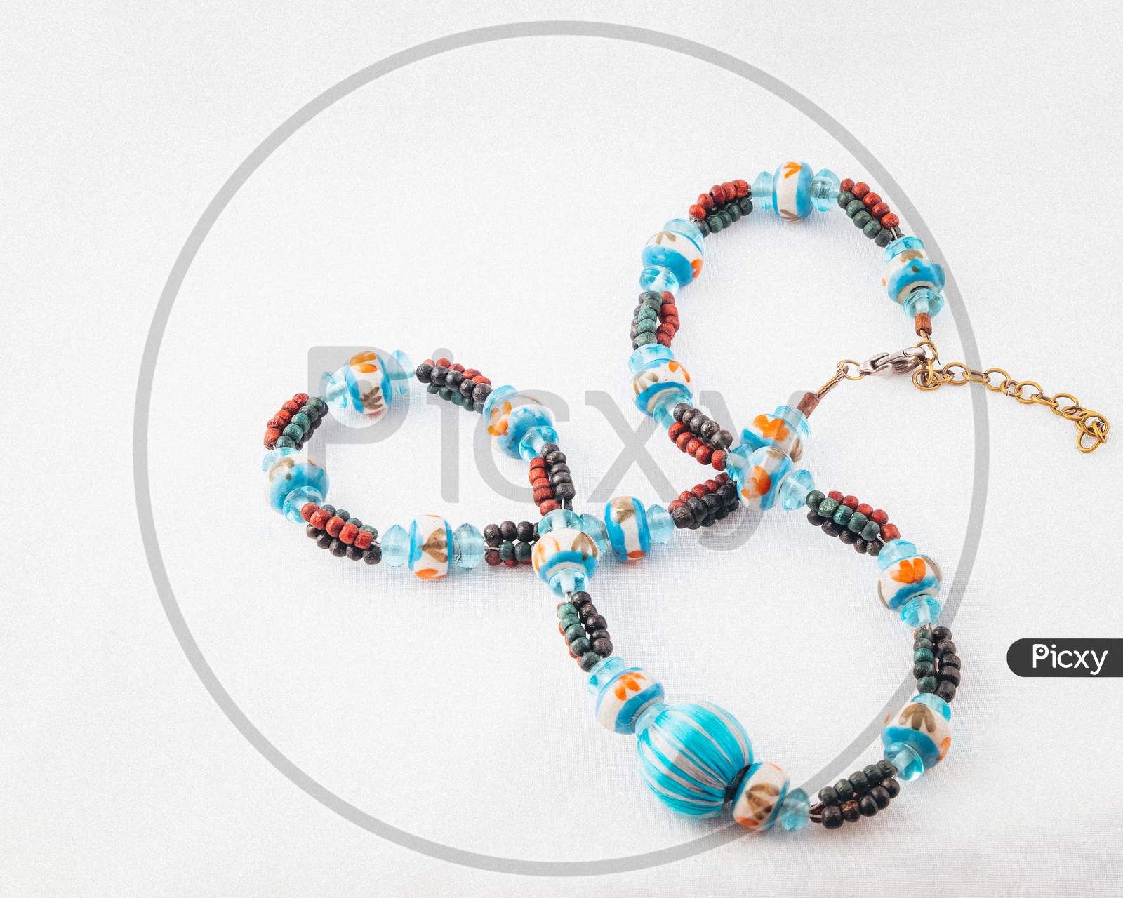 Strand of chunky coloured beads laid on white background