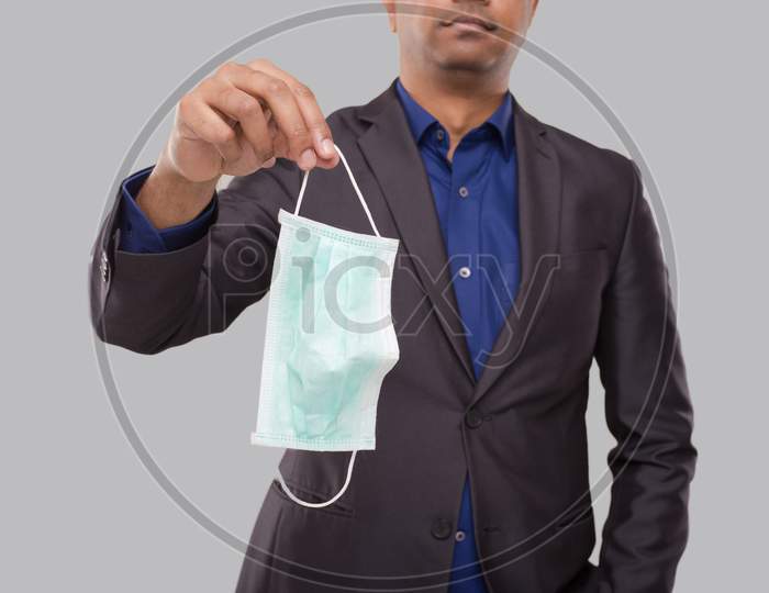 Businessman Holding Medical Mask Isolated Close Up. Indian Business Man With Medical Mask In Hands